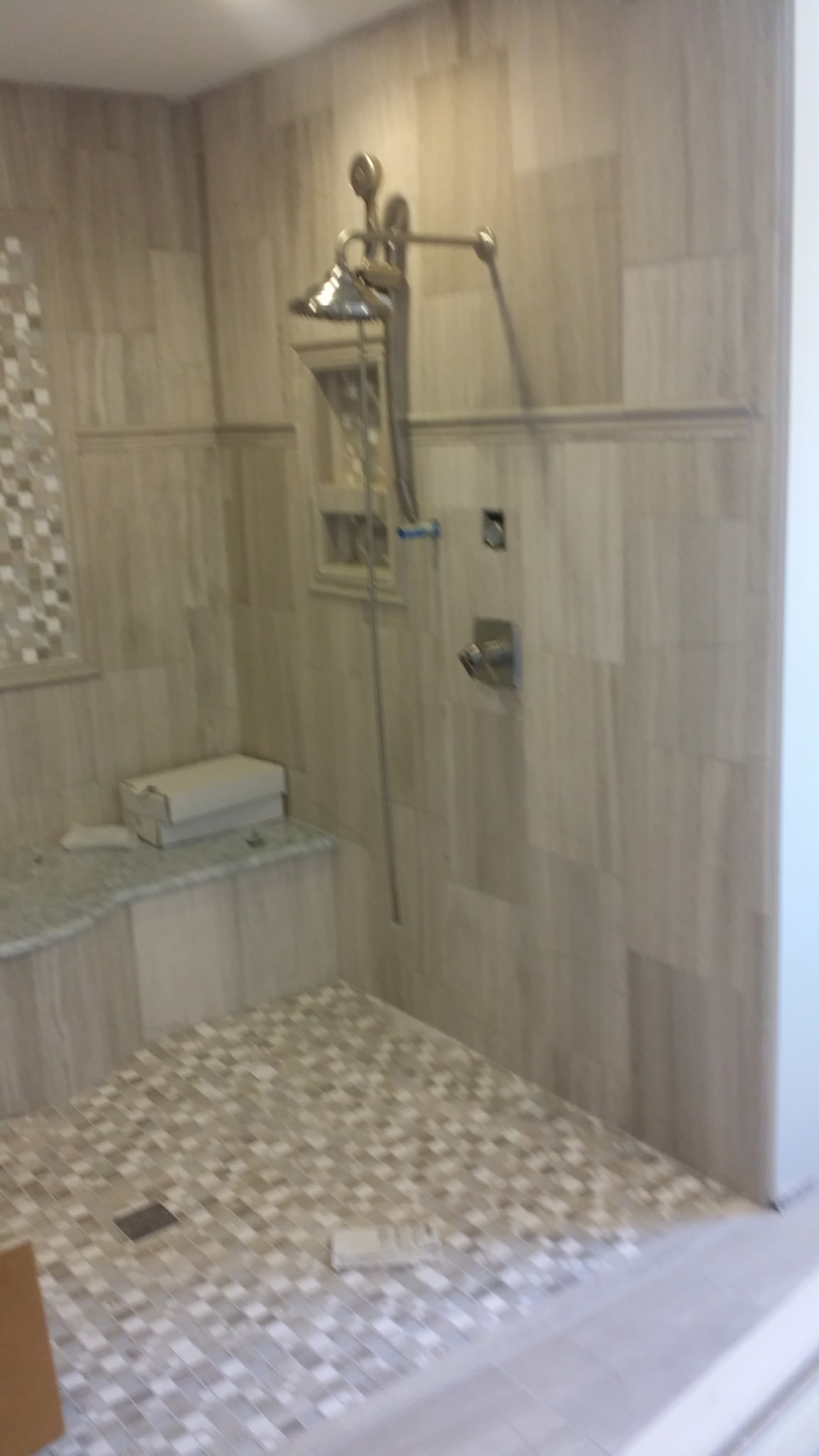 Finished walk-in shower with rainfall head, handheld, and tiled bench