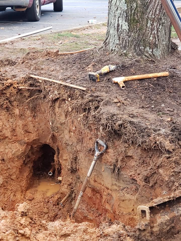 Underground pipe repair pit with tools and replacement fittings